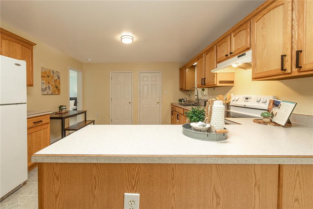 222 Hines Road Slippery Rock, PA 16057 - Photo 16 of 42 a kitchen with sink a refrigerator and wooden cabinets