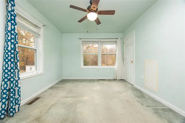 an empty room with a ceiling fan and a window