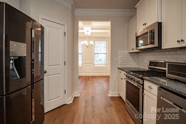 a kitchen with stainless steel appliances granite countertop a stove a refrigerator and a microwave