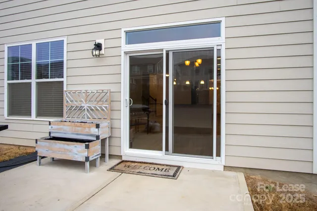 a view of house with a yard and potted plants