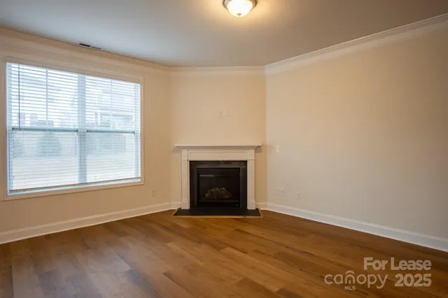 an empty room with a fireplace and windows