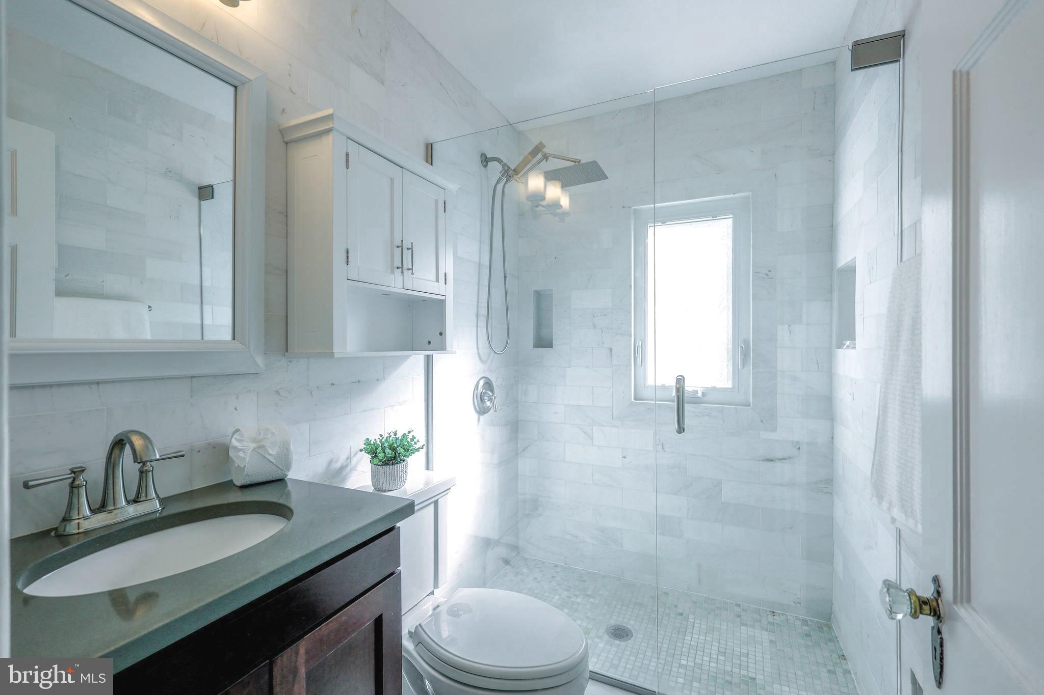 3230 Military Road Northwest Washington, DC 20015 - Photo 39 of 61 a bathroom with a granite countertop sink a toilet and shower