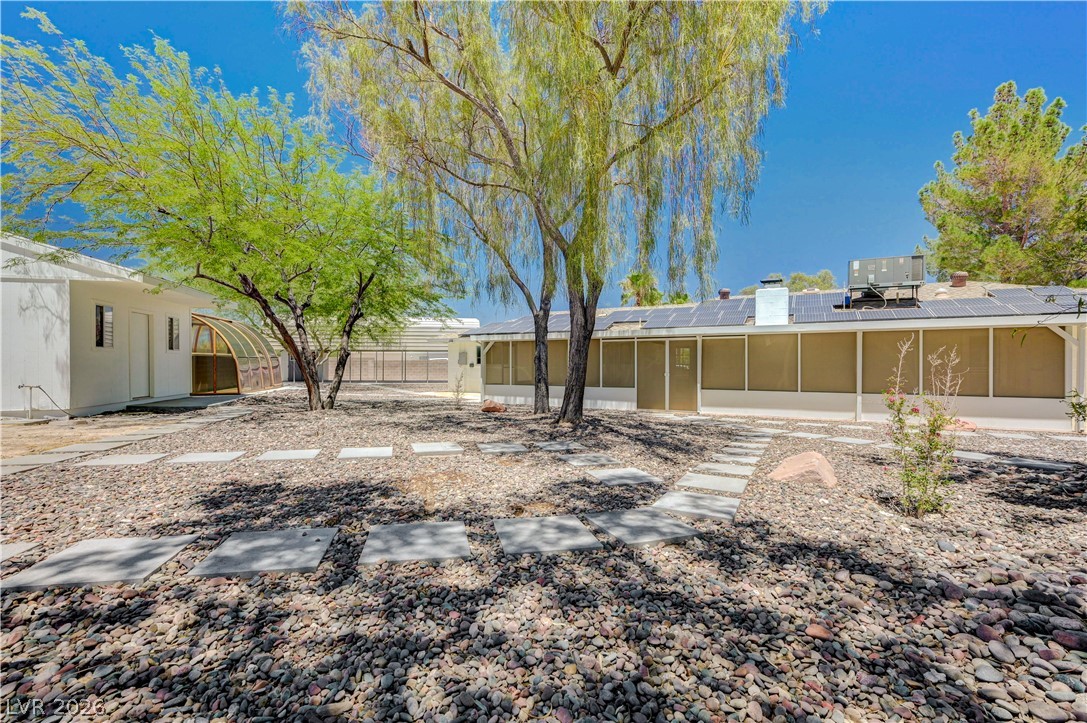 7631 Bermuda Road Las Vegas, NV 89123 - Photo 45 of 64 A tranquil desert landscape surrounds this unique residence, offering abundant outdoor space and mature trees for shade.