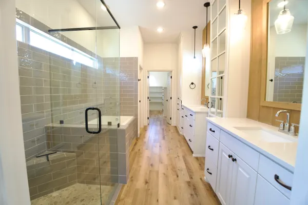 a bathroom with a double vanity sink a mirror and shower