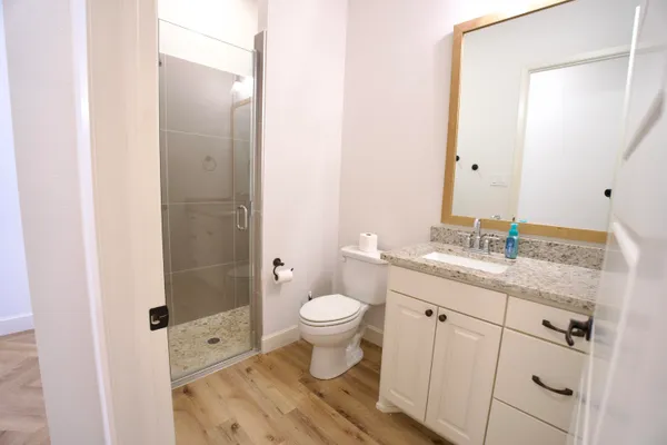 a bathroom with a granite countertop sink toilet and shower