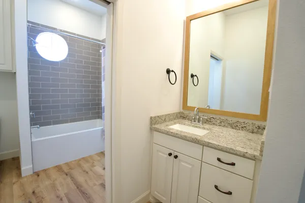 a bathroom with a granite countertop sink and a mirror