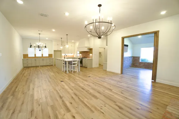 a view of a dining room with furniture wooden floor and chandelier