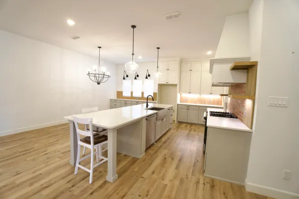 a large kitchen with a table and chairs