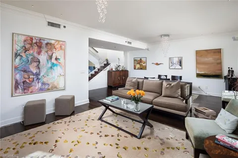 a living room with furniture a rug and wooden floor