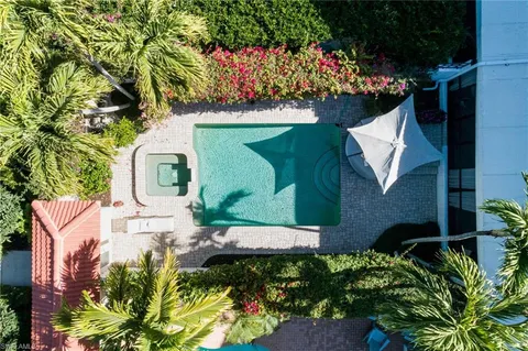 an aerial view of a house with a yard and large trees