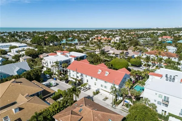 an aerial view of a city with lots of residential buildings and ocean view
