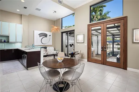 a kitchen with a dining table chairs and cabinets