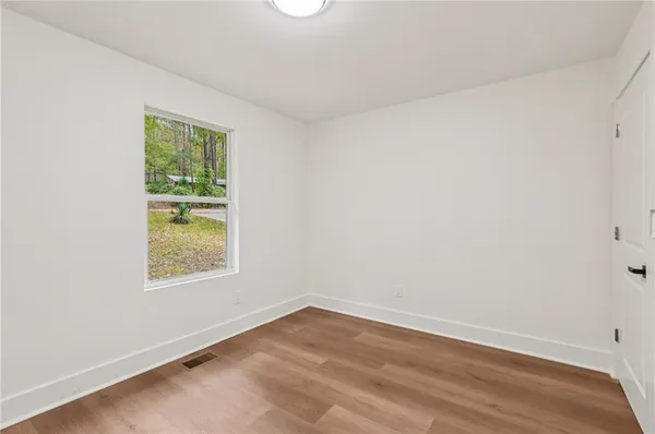 wooden floor in an empty room with a window