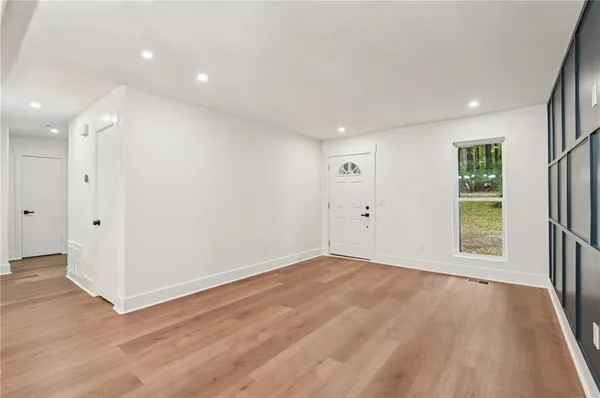 an empty room with wooden floor and windows