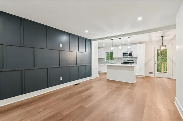 a kitchen with granite countertop a refrigerator and white cabinets