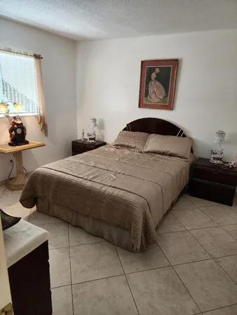 a bedroom with a bed and a painting on the wall