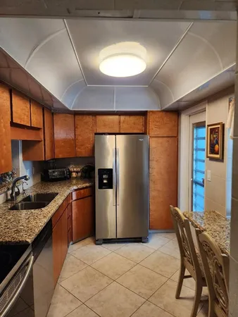 a kitchen with stainless steel appliances granite countertop a refrigerator a sink a stove and island