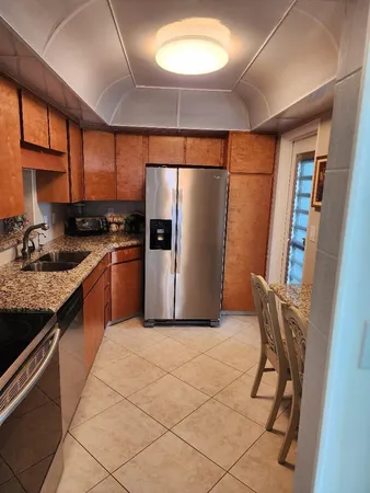 a large kitchen with stainless steel appliances granite countertop a stove a refrigerator a sink and dishwasher