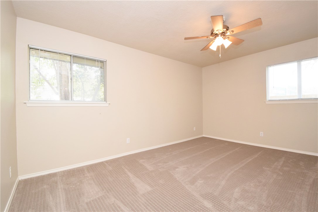 6400 Brookside Drive, Unit B Austin, TX 78723 - Photo 6 of 25 an empty room with windows and chandelier fan