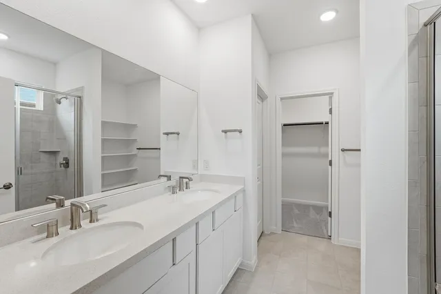 a bathroom with a double vanity sink mirror and shower