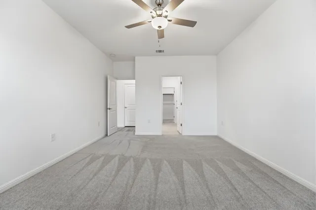 a view of a room with a ceiling fan and hardwood floor