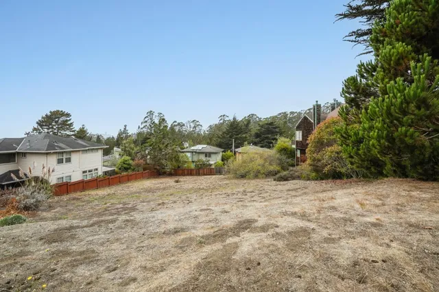 a view of a dirt road with a building in the background