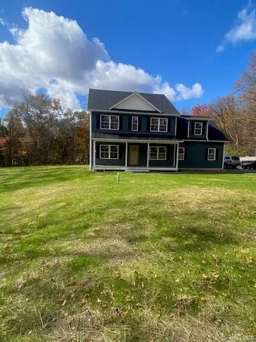 a view of a house with yard and sitting area