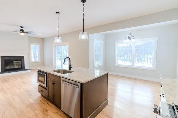 a view of empty room with wooden floor and ceiling fan