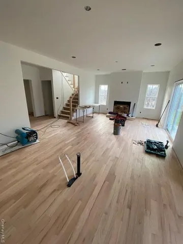 a view of a room with gym equipment and wooden floor
