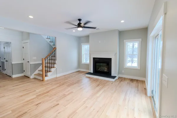 a large kitchen with stainless steel appliances kitchen island granite countertop a refrigerator a stove and white cabinets with wooden floor