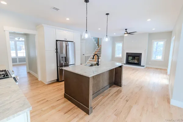 a kitchen with stainless steel appliances granite countertop a sink dishwasher a refrigerator and a stove with wooden floor