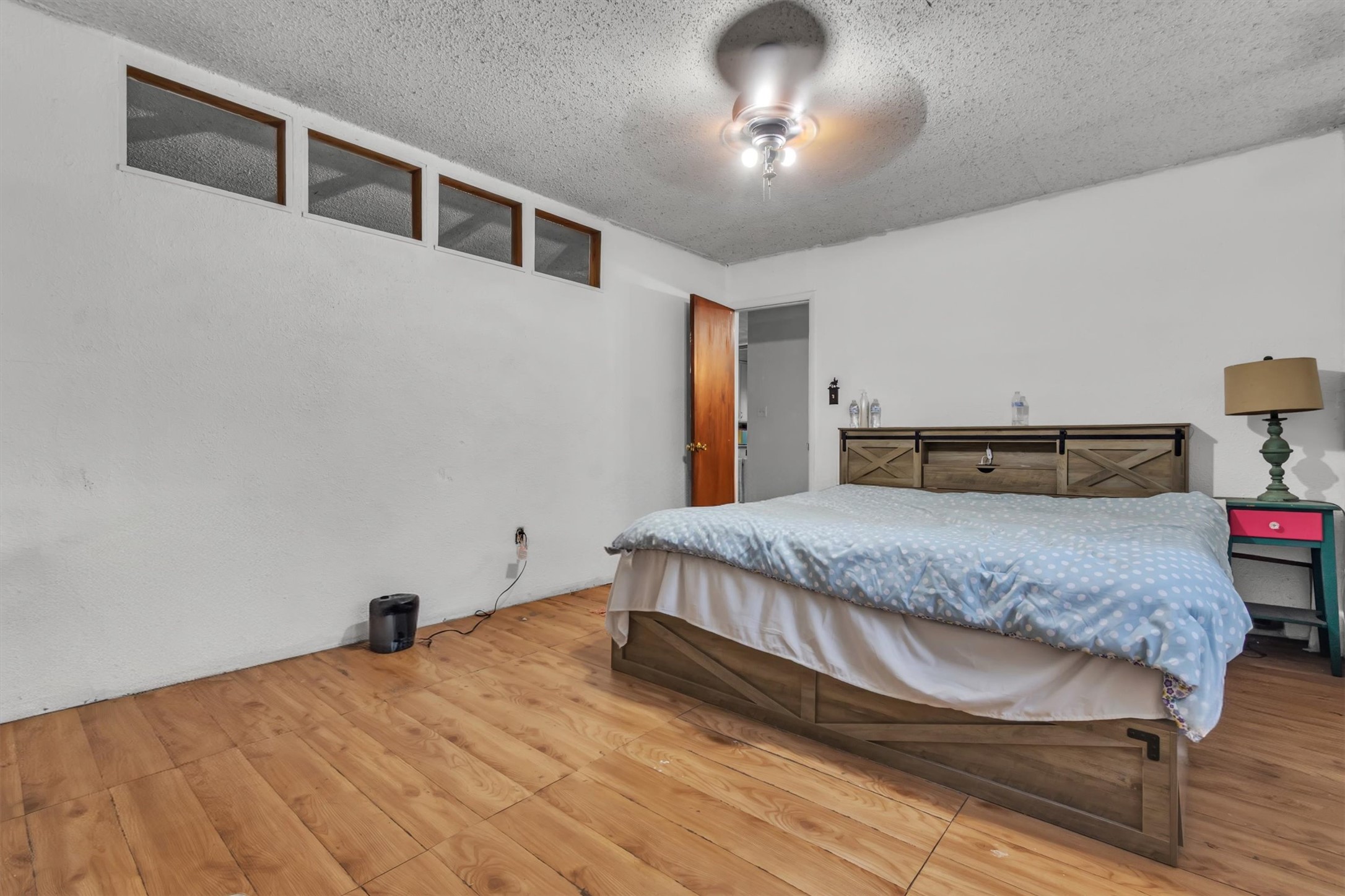149 Wayside Drive Elgin, TX 78621 - Photo 12 of 24 Bedroom featuring wood finished floors, a textured ceiling, and a ceiling fan
