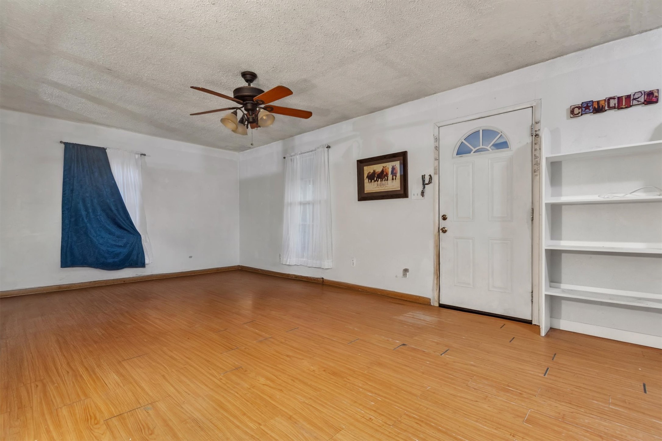 149 Wayside Drive Elgin, TX 78621 - Photo 4 of 24 Foyer featuring a textured ceiling, light wood finished floors, and ceiling fan