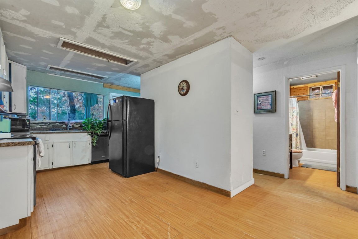 146 Wayside Drive Elgin, TX 78621 - Photo 9 of 24 Kitchen with white cabinets, stainless steel appliances, light wood-style flooring, and dark countertops