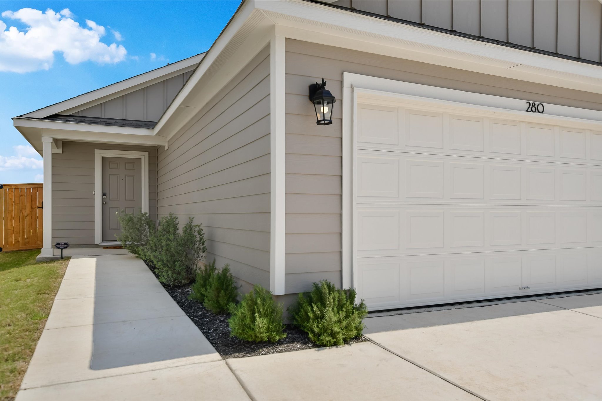 280 Alcatraz Loop Jarrell, TX 76537 - Photo 1 of 1 Doorway to property featuring concrete driveway, fence, board and batten siding, and a garage