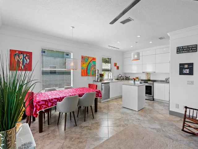 a kitchen with stainless steel appliances kitchen island granite countertop a table and chairs in it