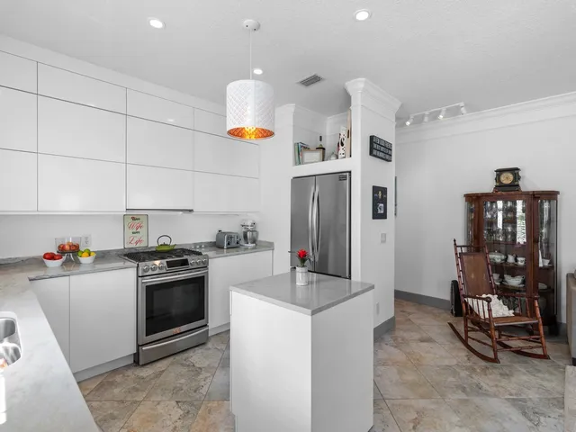 a kitchen that has a lot of cabinets and refrigerator in it