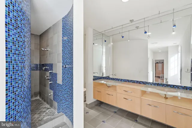 a bathroom with a granite countertop bathtub a sink a mirror a shower and vanity