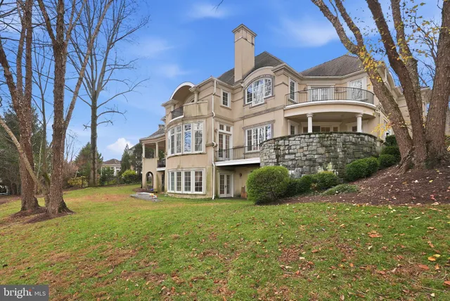 a view of a big house with a big yard and large trees
