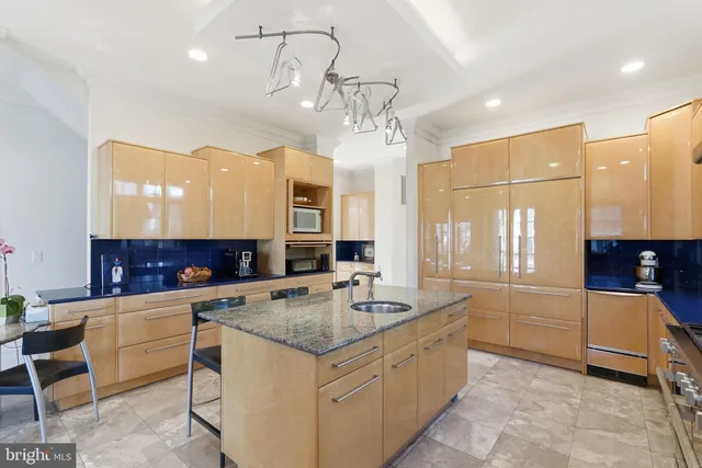 a kitchen with stainless steel appliances granite countertop a sink a stove top oven a counter space and cabinets