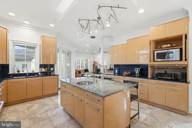 a large kitchen with kitchen island a large counter top space appliances and cabinets