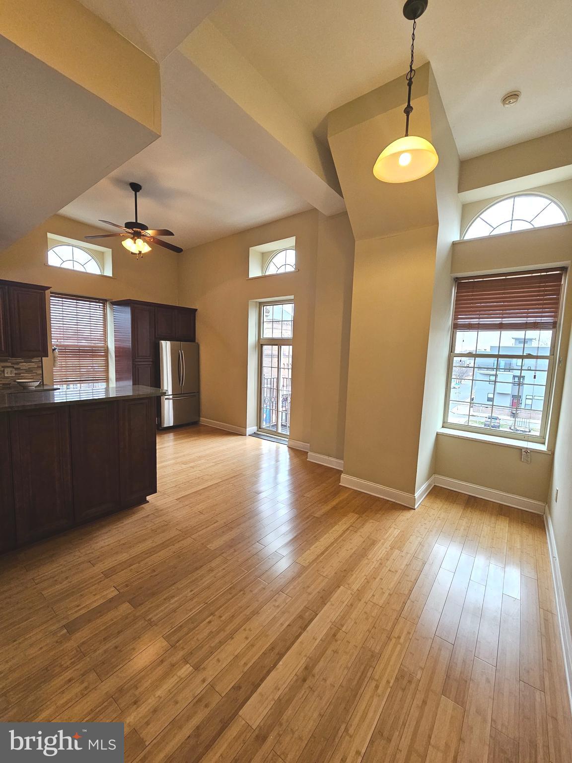 1268 South 26th Street, Unit 3E Philadelphia, PA 19146 - Photo 5 of 13 an empty room with wooden floor and windows