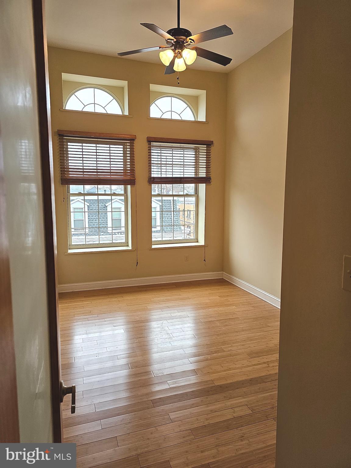 1268 South 26th Street, Unit 3E Philadelphia, PA 19146 - Photo 9 of 13 a view of an empty room with window and wooden floor