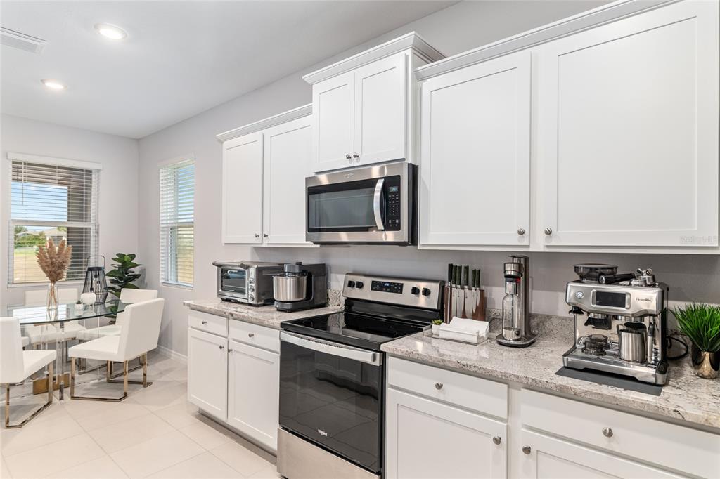 6243 Southwest 89th St Road Ocala, FL 34476 - Photo 28 of 57 a kitchen with stainless steel appliances granite countertop a stove a sink and a microwave