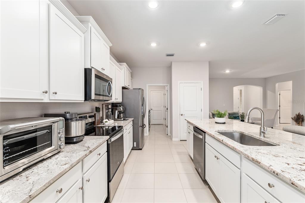 6243 Southwest 89th St Road Ocala, FL 34476 - Photo 30 of 57 a large kitchen with a stove top oven a sink a counter space and cabinets