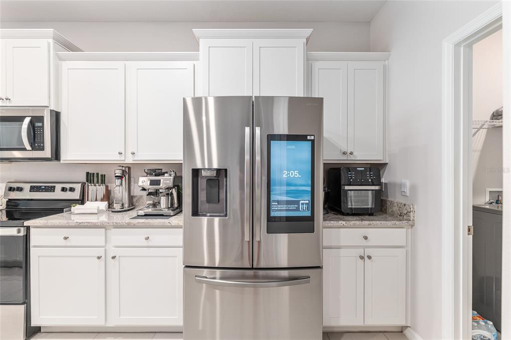 6243 Southwest 89th St Road Ocala, FL 34476 - Photo 32 of 57 a kitchen with refrigerator a microwave stove and cabinets