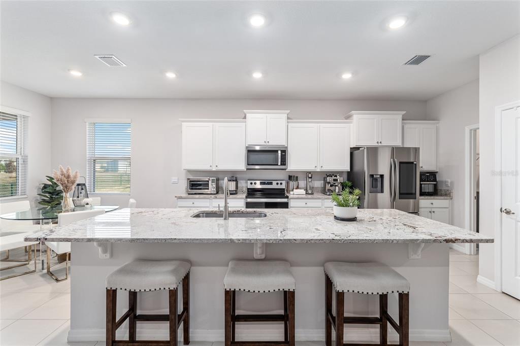 6243 Southwest 89th St Road Ocala, FL 34476 - Photo 33 of 57 a kitchen with granite countertop white cabinets and stainless steel appliances