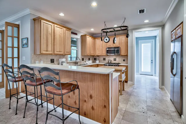 a kitchen with stainless steel appliances granite countertop a stove a sink and a refrigerator