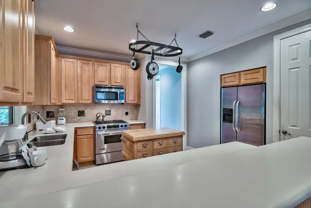 a kitchen with stainless steel appliances granite countertop a sink a stove and a refrigerator