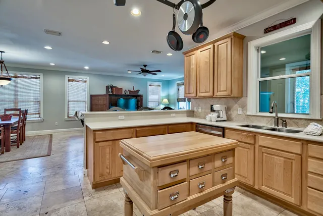 a kitchen that has a lot of cabinets in it and wooden floors